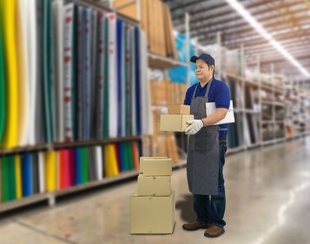 Male staff Delivering products Sign the signature on the product receipt form with parcel boxes Blurred the background of the warehouseの写真素材