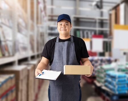 Male staff Delivering products Sign the signature on the product receipt form with parcel boxes Blurred the background of the warehouseの写真素材