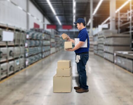 Male staff Delivering products Sign the signature on the product receipt form with parcel boxes Blurred the background of the warehouseの写真素材