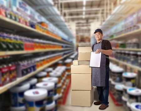 Male staff Delivering products Sign the signature on the product receipt form with parcel boxes Blurred the background of the warehouseの写真素材