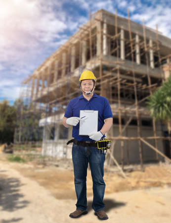Male Building contractor Sign the signature on the Construction progress form Blurred the background of the warehouseの写真素材
