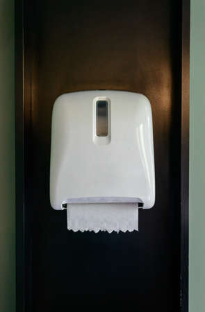 White Tissues paper towel dispenser on wooden wall in public toiletの写真素材