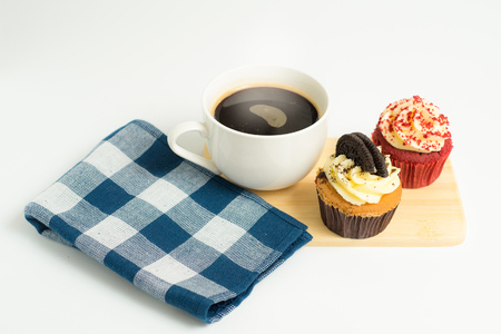 Top view of black coffee cup with red velvet and chocolate cookies cupcakes on wooden plate in white backgroundの写真素材