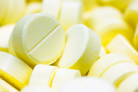 Pharmacy theme, Heap of yellow round medicine tablet antibiotic pills. Shallow DOFの写真素材