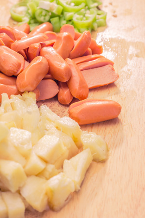 Preparing a stir fry of stewed vegetables and sausageの写真素材