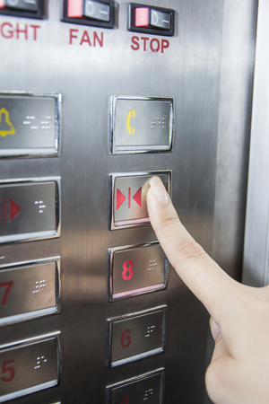 hand press open door button in elevator
