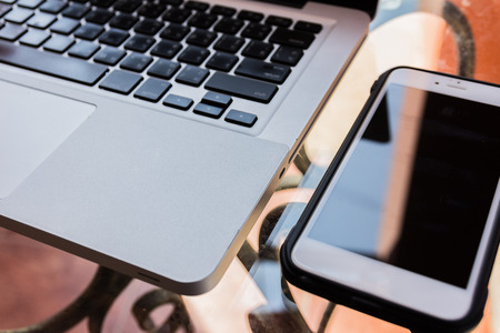 Laptop computer, phone ,books and plant on the table in swimming pool, small depth of field.の写真素材