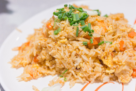 Homemade Chinese fried rice with vegetables, chicken and fried eggs served on a plate (Selective Focus, Focus one third into the dish)の写真素材