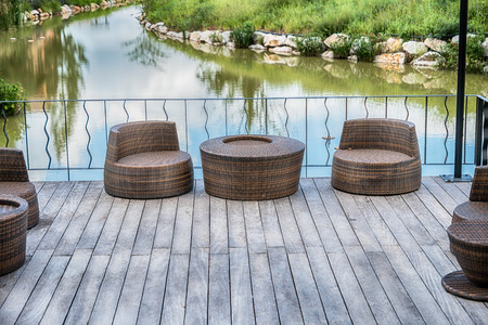 The wood table on natural outdoor of a restaurant with tree and cloudy sky