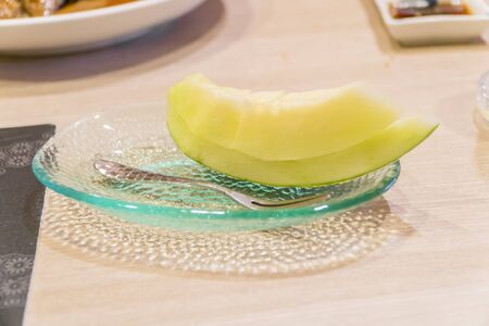Juicy slice cantaloupe melon on ceramic dish.