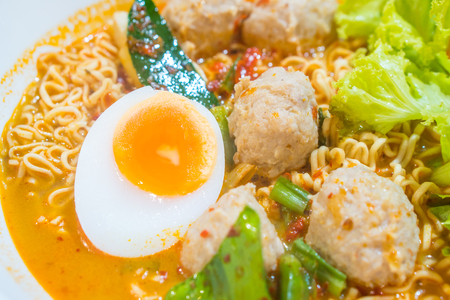 Thai spicy noodle or tom yum with boiled egg on the wooden table.の写真素材