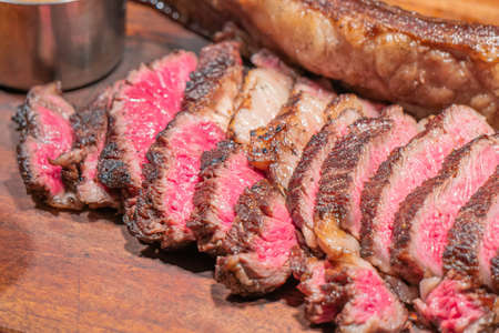Dry-aged marble beef steak Tomahawk on wooden board with spices. Close-up, dinner concept.