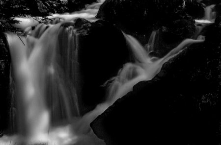 Waterfall falling slowly from the Gorgas del Alba in the Benasque Valley. Illumination of dawn with magical and esoteric light. Black and white.の写真素材