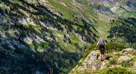 Hiker woman on top of a mountain watching mountainous landscapeの写真素材