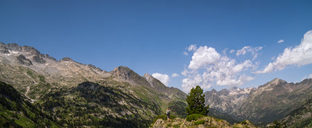 Hiker woman on top of a mountain watching mountainous landscape of Pyreneesの写真素材