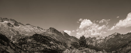 Hiker woman on top of a mountain watching mountainous landscape of Pyrenees in black and white.の写真素材