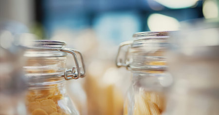 Close-up of glass jars with macaroni in the background