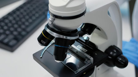 Close-up of a microscope in focus with 10x objective lens on a clean workspace