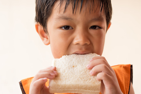 Boy is eating sandwich bread.の写真素材