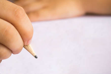 boy write note on white paper with pencilの写真素材