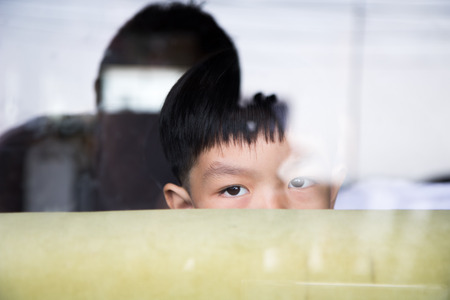 boy hide himself behind sofa in the mirror room.の写真素材