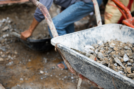 labor and wheelbarrow with pebble at construction site.の写真素材