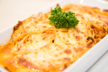 Spaghetti cheese baked in white bowl on the table.の写真素材