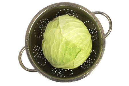 Just washed fresh cabbage in a colander with water-drops. On isolated on white background. Top view.の写真素材