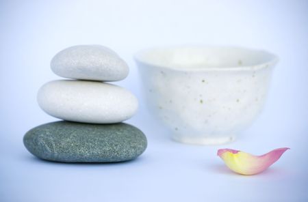 Pyramid of pebbles, cup and rose petal in tranquil still life. Spa series.の写真素材