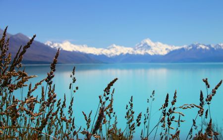 Beautiful mountain turquoise color lake, blue sky and snow peaks reflecting in the water. Lake Tekapo, Mount Cook National Park, New Zealandの写真素材