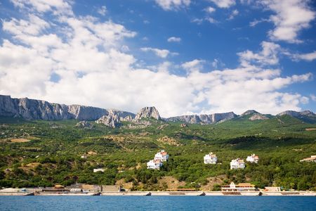 Ukraine, Crimea. A kind from the sea at coast. Mountains, cottages, clouds, quay.の写真素材