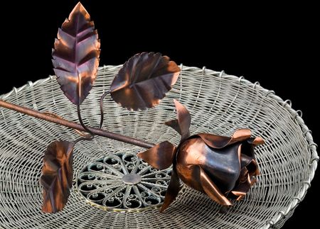 Metal rose on a wattled metal trayの写真素材