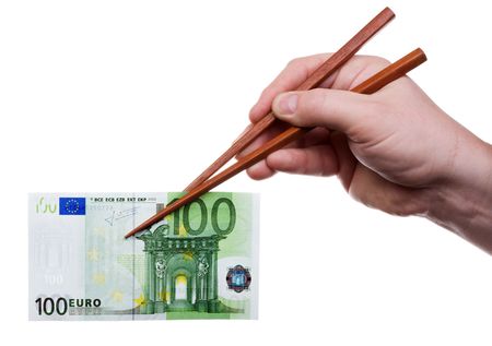 Hand holding the chopsticks with banknote. Isolated on white [with clipping path].の写真素材