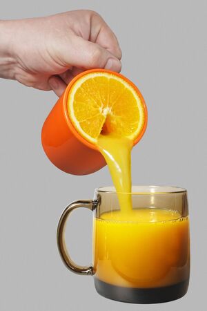 Orange mug with orange juice stream.の写真素材