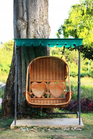 rattan swing bench in gardenの写真素材