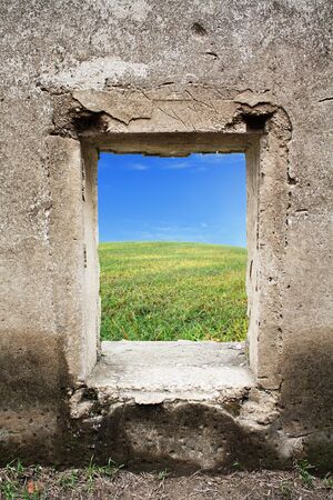 green grass and blue sky behind old castle windowの写真素材