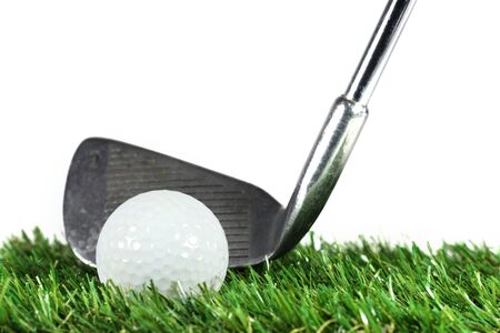 golf iron and golf ball on green grassの写真素材