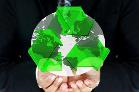 Business man carrying recycle symbol cover earth の写真素材