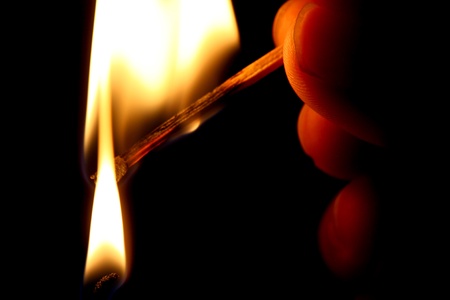 hand use matchstick to light a candleの写真素材