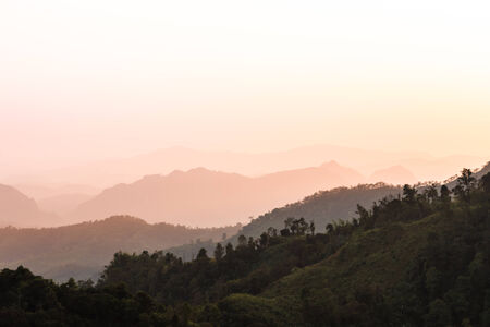 silhouette mountains under mist in the eveningの写真素材