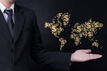 business man showing World map made with dollar signの写真素材