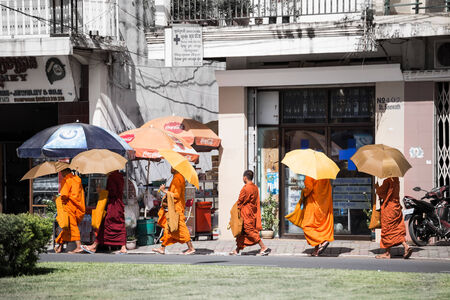 PHNOM PENH, CAMBODIA - JUNE 5  Unidentified Buddhist monks with umbrella walking on street in Phnom Penh, Cambodia on 5 June 2014 のeditorial素材