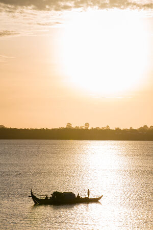 Silhouette fishing boat under sunsetの写真素材