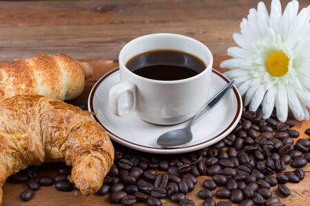 Breakfast with coffee, croissant and sausage dough on wooden tableの写真素材