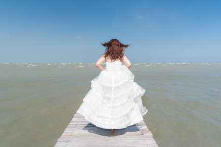 Bride standing in front of the seaの写真素材