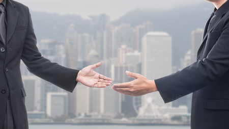 business man with an open hand with blurred buildings backgroundの写真素材