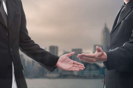 business man with an open hand with blurred buildings backgroundの写真素材