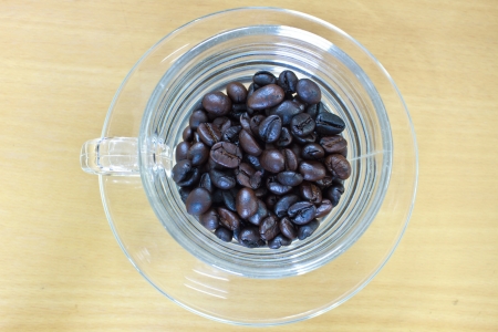 coffee beans in cup on the wood tableの写真素材