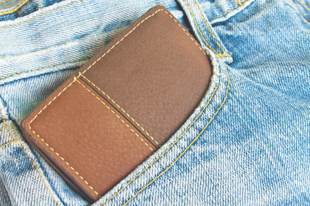 Brown wallet in jeans trousers back pocket, close up textureの写真素材