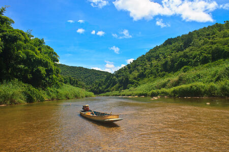 River in deep forest, river in evergreen forest with boat の写真素材